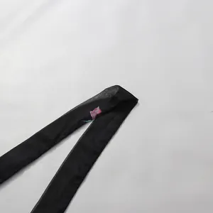 Détail d'une ceinture en mousseline noire avec imprimé floral rose pour une robe.