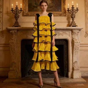 Elegant yellow tiered ruffled dress with black shoulder straps in a classical room setting.