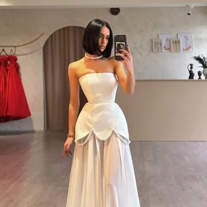 Elegant white strapless evening dress with pearl beadwork and sheer mesh detail.