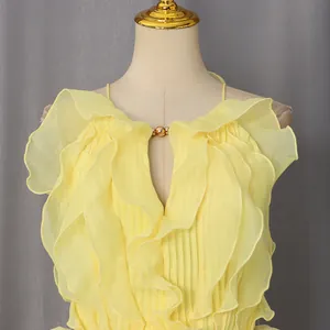 Detail of yellow sleeveless dress featuring layered ruffles and v-neckline design