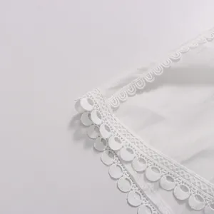 Gros plan d'une robe blanche de style français avec une broderie élégante.