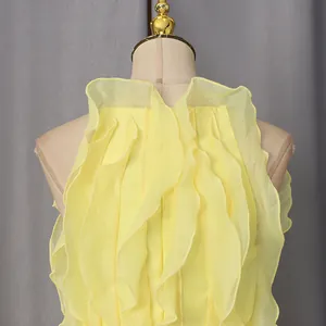 Close-up detail of a vibrant yellow sleeveless dress featuring elegant vertical ruffles