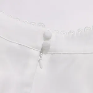 Détail rapproché de boutons recouverts de tissu blanc et fermeture éclair invisible