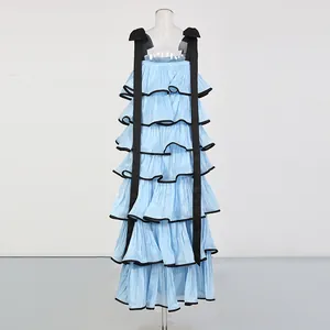 Detailed view of a light blue tiered maxi dress with black tie-shoulder straps.