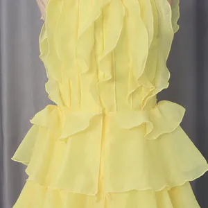 Detailed view of yellow sleeveless dress featuring layered ruffles and fabric texture