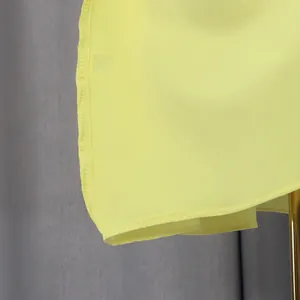 Detailed close-up showing high-quality hemline stitching on a yellow sleeveless ruffle dress