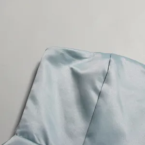 Macro detail showing the smooth texture and fine stitching of light blue satin dress
