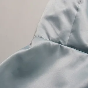 Detailed close-up of light blue satin fabric showing smooth texture and sewing seam