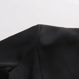 Detail der Schulternaht und des glatten schwarzen Stoffes am eleganten Kleid