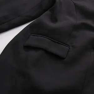 Detailaufnahme der Pattentasche und der Stoffstruktur eines schwarzen Blazerkleides
