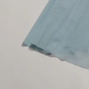 Close-up of light blue mesh fabric detail for elegant evening dress