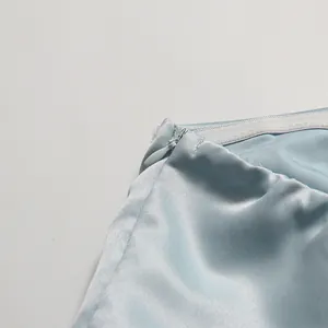 Macro detail showing the invisible zipper and interior anti-slip tape on a light blue satin dress.