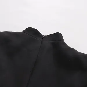 Detailaufnahme von Stehkragen und verdecktem Reißverschluss an einem schwarzen Businesskleid.