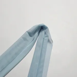 Detailed view of light blue mesh fabric strap on an elegant designer evening dress.
