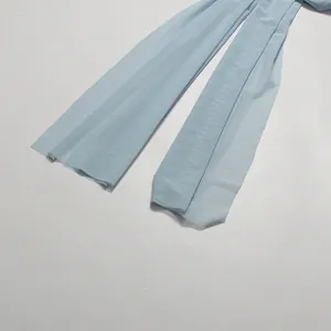 Macro detail view showing the light blue mesh fabric streamers of a formal evening dress