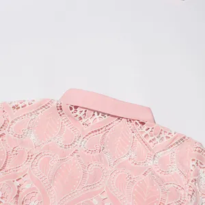 Close-up of pink heavy embroidery lace fabric with leaf patterns on dress collar