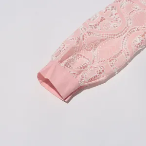 Close-up of intricate pink lace embroidery and buttoned cuff on a French style dress.