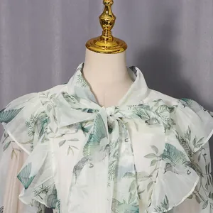 Detail eines eleganten Blumenkleides mit Rüschenkragen und Schleife am Ausschnitt