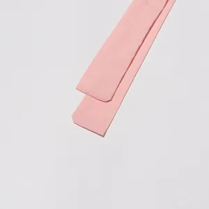 Close-up detail view of a soft pink fabric waist tie for a stylish French-style dress.