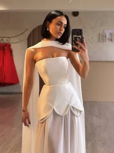 Elegant white strapless evening dress with pearl bead trim and a sheer cape detail