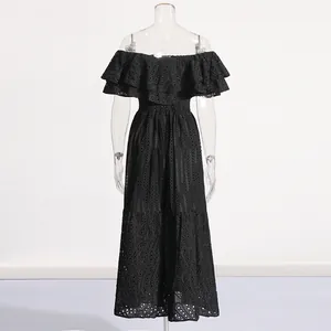 Détail d'une robe longue noire en dentelle anglaise avec volants épaules
