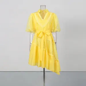 Detailed view of yellow V-neck lace dress with puff sleeves and asymmetrical hemline