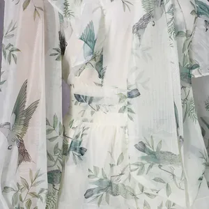 Nahaufnahme des Vogel- und Blattdrucks auf einem französischen Mesh-Kleid mit Rüschen