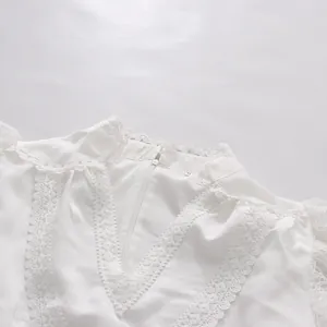 Detailed close-up of white lace V-neck collar on a feminine tea-break style dress