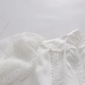 Close-up detail of elegant white lace puff sleeves and floral crochet trim on dress