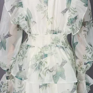 Detailaufnahme von Kleid mit Vogelprint, Netzeffekt, Rüschen an Taille und Ärmeln