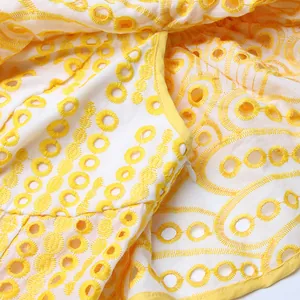 Détail du tissu brodé à œillets jaune et blanc avec fermeture éclair invisible d'été