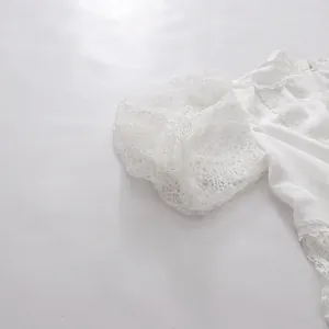 Close-up detail of a white lace puff sleeve on an elegant tea break style dress.