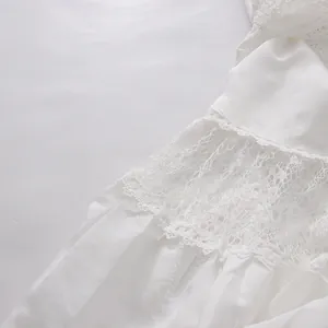 Close-up view of delicate white lace embroidery and soft fabric texture on a tea-break dress