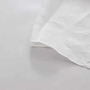 Close-up of the white fabric texture and hem stitching on a tea-break style dress