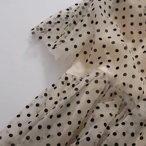 Macro detail of retro black polka dots on multilayer cream mesh tulle fabric