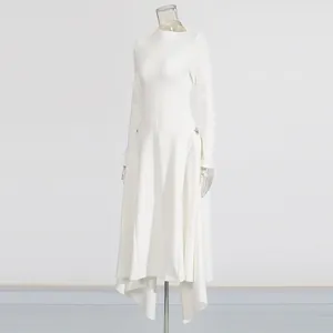 Detail van een witte jurk met lange mouwen, onregelmatige zoom en centrale verticale naad.