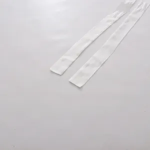 Close-up view of the white fabric waist tie ribbons for a V-neck tea break dress