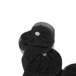 Nahaufnahme von schwarzen Plisseerüschen mit eleganten, funkelnden Strassverzierungen am Kleid