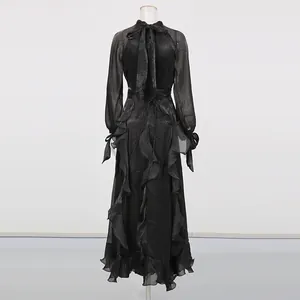 Rückansicht Detail mit kaskadierenden Rüschen und Schleife an einem schwarzen Abendkleid