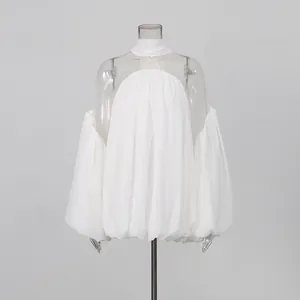 Vista detallada del patchwork de malla blanca transparente y gasa plisada en esta blusa de manga