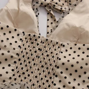 Close-up detail of the smocked back and halter bow tie on a vintage polka dot mesh dress