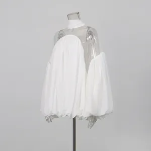 Detalle lateral de una blusa de gasa y malla blanca semitransparente en maniquí