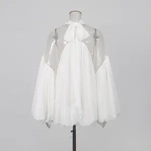 Vista trasera de blusa de gasa blanca con lazo en el cuello y mangas farol.
