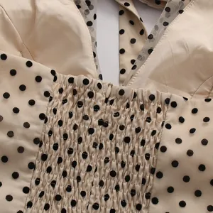 Close-up view of back smocking detail and hidden zipper on vintage polka dot mesh dress