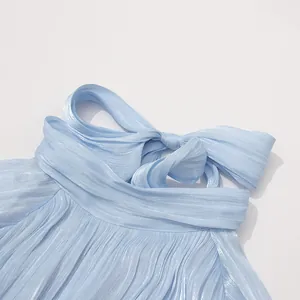 Nahaufnahme des glänzenden plissierten Stoffes und Schleifendetails eines hellblauen Abendkleides