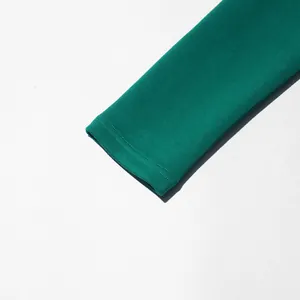 Detail van de smaragdgroene jurkmouw met hoogwaardige dubbele stiksels aan de manchetten