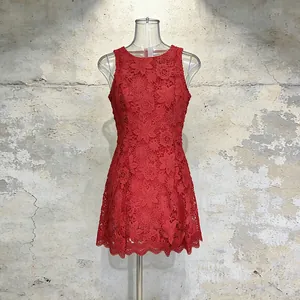 Detailed view of an elegant red sleeveless floral lace mini dress presented on a mannequin.