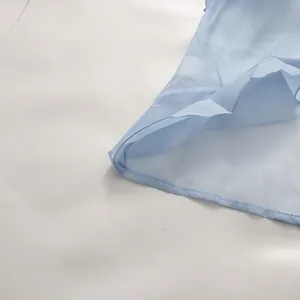 Detail view of light blue sheer chiffon ruffle hem and delicate stitching of the dress
