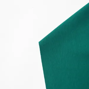 Gedetailleerde macro-opname van de donkergroene stof van deze elegante geplooide maxi-jurk