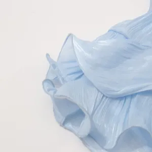 Makro-Detailaufnahme des hellblauen französischen Abendkleides mit plissierter Rüschenstruktur